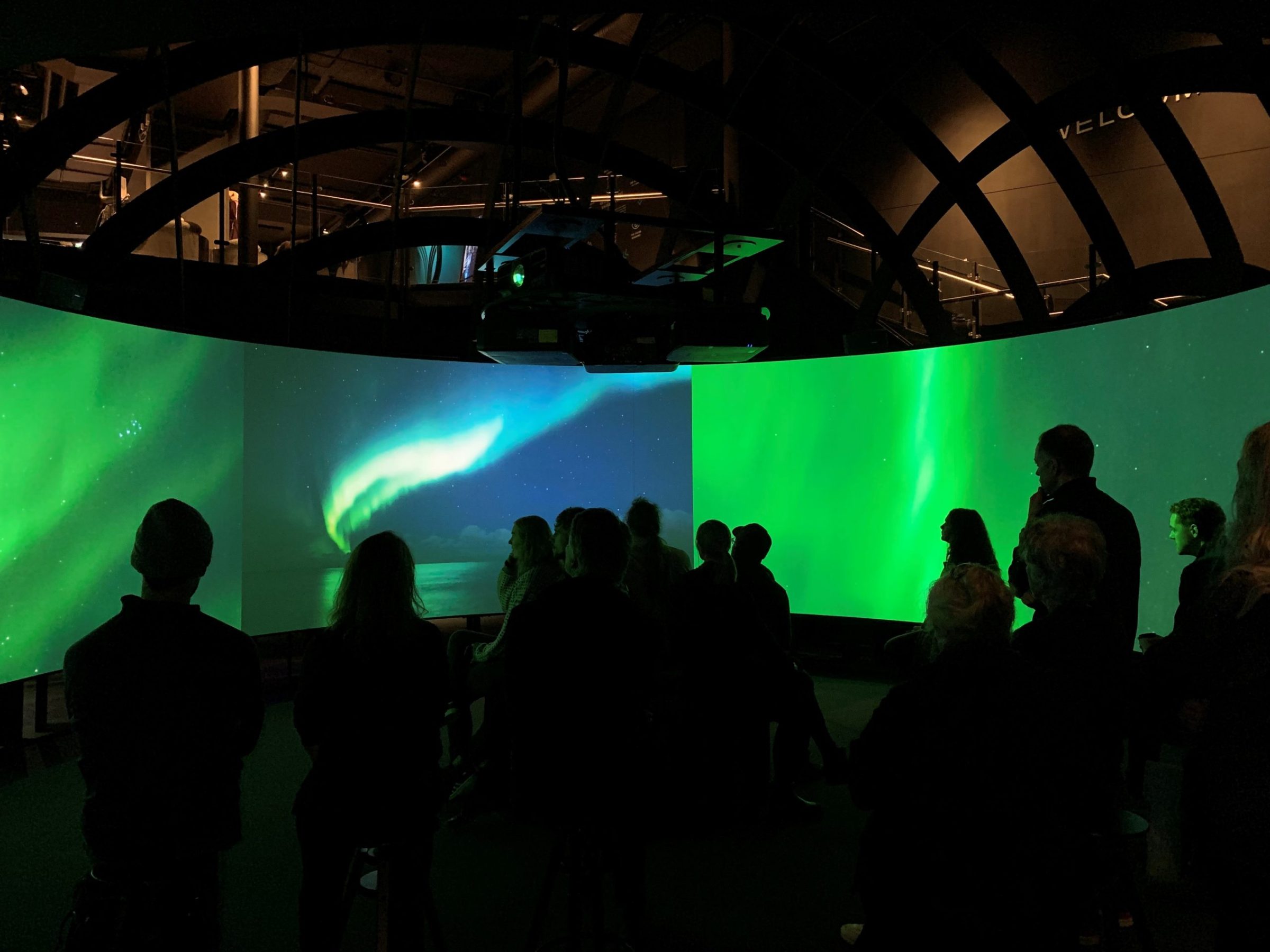 a group of people standing in front the Viking experience in a 270° cinema and Hologram Theatre