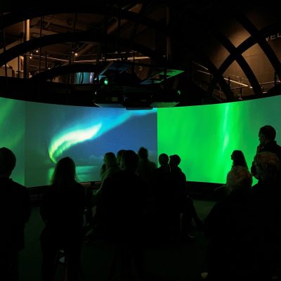 a group of people standing in front the Viking experience in a 270° cinema and Hologram Theatre
