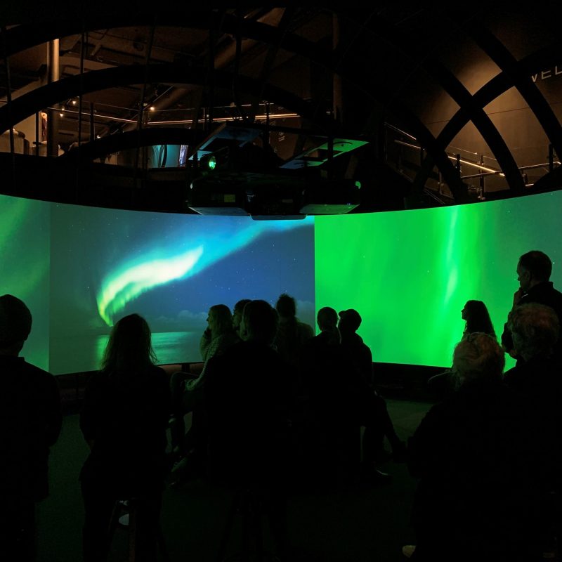 a group of people standing in front the Viking experience in a 270° cinema and Hologram Theatre